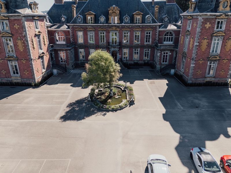 Vue aérienne de la façade principale et de la fontaine – Château de la Neuville
