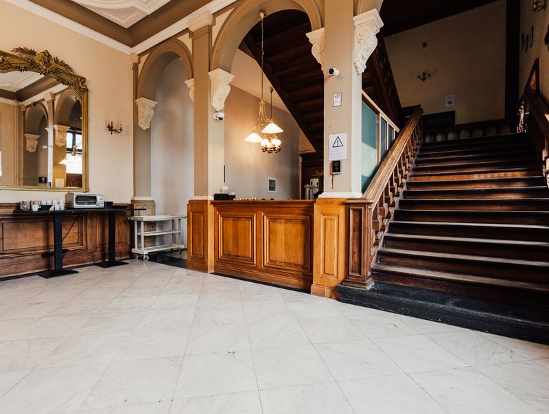 Comptoir de réception et grand escalier – Château de la Neuville