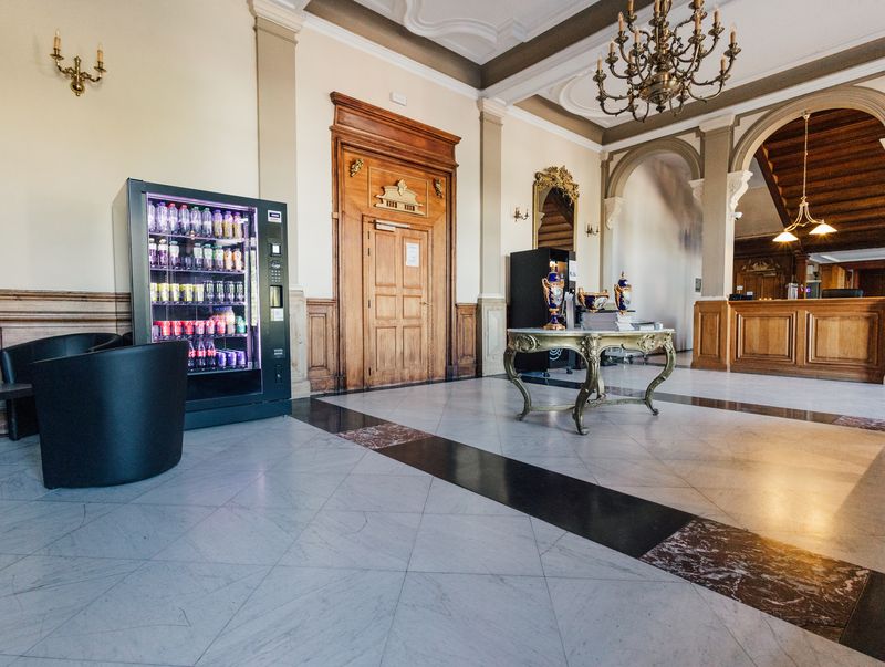 Hall d'accueil en marbre sous un lustre – Château de la Neuville